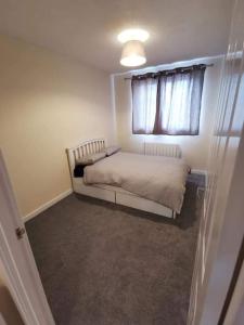 een kleine slaapkamer met een bed en een raam bij Slateford Road Modern Apartment in Edinburgh