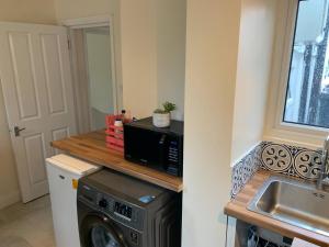 a kitchen with a washing machine and a sink at Daisy in Whetstone