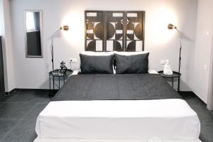 a bedroom with a large white bed with two side tables at Venizelou Comfort & Living II in Kavala
