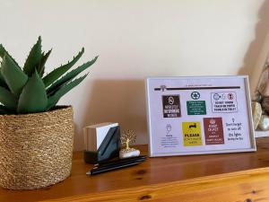 un panneau assis au-dessus d'une table avec une plante dans l'établissement homonatura. sense of native living., à Pyrgos