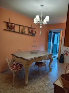 een eetkamer met een tafel en stoelen en een kroonluchter bij LA MIA CASA DI CAMPAGNA MARIA in Santa Giustina
