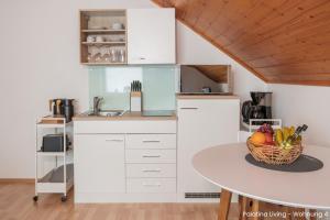 una cocina con mesa y un bol de fruta en Palatina Living, en Fischbach