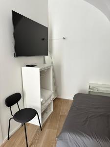 a bedroom with a bed and a chair and a flat screen tv at SUITE 1 in Palo del Colle
