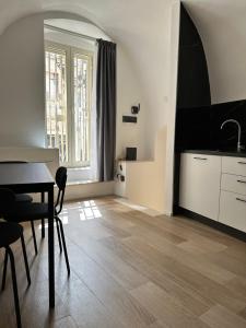 a living room with a table and a kitchen at SUITE 1 in Palo del Colle