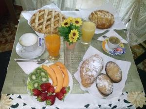 a table with a breakfast of bread and fruit and juice at Bed&Breakfast La Cornucopia in Gallipoli