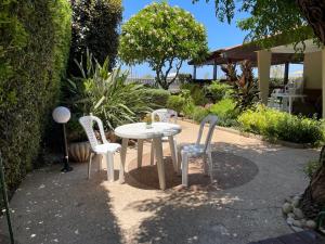 a white table and chairs in a garden at Breezot Yam in Nahariyya +37 photos