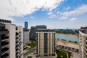 Cette chambre offre une vue sur une ville avec de grands bâtiments et une rivière. dans l'établissement Belgrade Waterfront - River Residence, à Belgrade