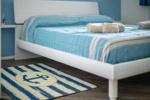 ein Bett mit einer blauen und weißen Tagesdecke und einem Teppich in der Unterkunft La casa di Olga e Terry in Uggiano la Chiesa