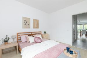 1 dormitorio con 1 cama grande con almohadas rosas en SuperApart Mińska 91, en Varsovia