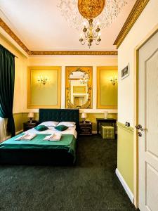 1 dormitorio con cama verde y espejo en Hotel Boutique Casa Vermont, en Bucarest