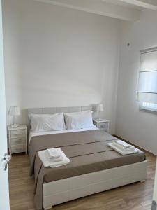 a white bedroom with a large bed and two night stands at Archiammare Sea in San Lorenzo