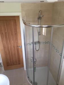 a shower with a glass door in a bathroom at Glen House Annexe in Bourne