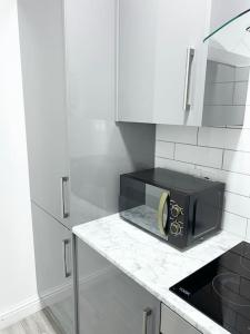 a kitchen with a black microwave on a counter at Johal Accommodation Ltd- NEC 1 bedroom studio apartment with free parking in Sheldon