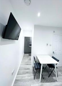 uma sala de jantar com uma mesa e uma televisão na parede em Johal Accommodation Ltd- NEC 1 bedroom studio apartment with free parking em Sheldon