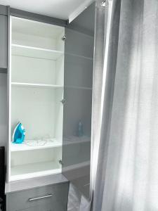 um armário branco com uma cortina ao lado de uma prateleira em Johal Accommodation Ltd- NEC 1 bedroom studio apartment with free parking em Sheldon