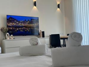 a bedroom with a bed with a flat screen tv at סוויטות עם נוף צמודות לים במתחם SeaSide היוקרתי עם בריכה in Eilat