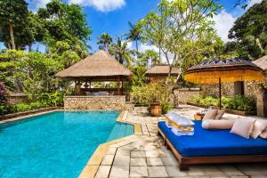 a villa with a swimming pool and a resort at The Oberoi Beach Resort, Bali in Seminyak