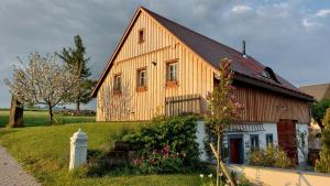 BertsdorfにあるHossies Hof - Luxus Ferienhaus Scheuneの花の咲く丘の上の木造家屋