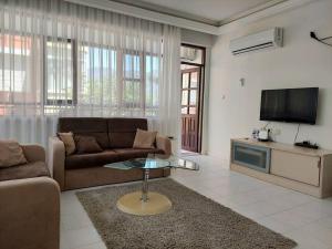 a living room with a couch and a tv at Villa on the Historic Castle Hill in Alanya