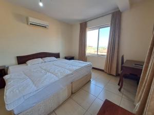 um quarto com uma cama grande e uma janela em Moshi Leopard Hotel em Moshi