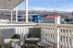 two chairs and a table on a balcony with snow at Two bedroom downtown apartment with balcony in Akureyri