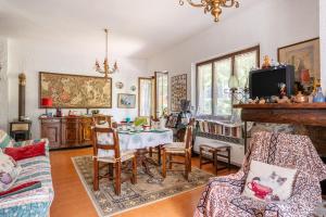 uma sala de estar com uma mesa e cadeiras e uma televisão em Villa Licia em Villa Basilica