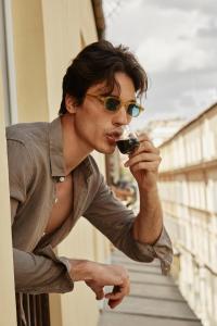 ローマにあるHOTEL VITE - By Naman Hotellerieのワインを飲むサングラスを着た男