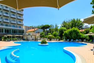 a large swimming pool in front of a hotel at Hotel Duca di Kent in Cesenatico
