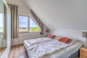 1 dormitorio con cama y ventana grande en Villapark Kamperfoelie 69, en De Koog