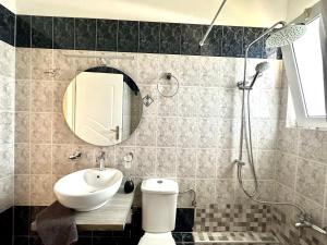 a bathroom with a sink and a shower with a mirror at Paralia Vergas Apartments in Verga Kalamata