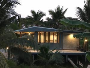 a house on the beach with palm trees at COCO HOME Homestay(โคโค่โฮม) in Ban Mo Kaeng Taek