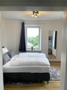 a bedroom with a large bed and a window at Homestay - Luxus Ferienwohnung in Bad Griesbach