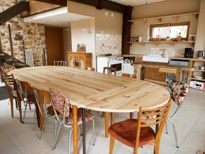 cocina con mesa de madera y sillas en La Rivée 