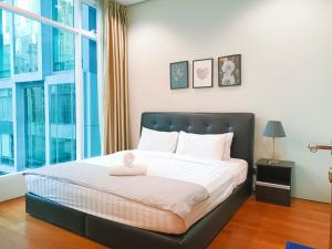 a bedroom with a bed with a large window at Soho Suites Klcc By Sweet Home in Kuala Lumpur