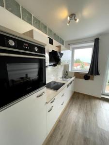 a kitchen with a sink and a stove top oven at Homestay - Luxus Ferienwohnung in Bad Griesbach