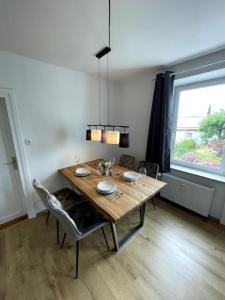 a dining room table with chairs and a large window at Homestay - Luxus Ferienwohnung in Bad Griesbach