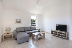 a living room with a couch and a flat screen tv at Sea view by Moro 3 in Malinska