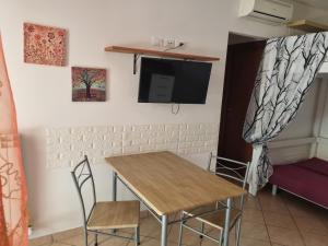 a dining room with a table and chairs and a tv at Alba Sweet in Alba Adriatica