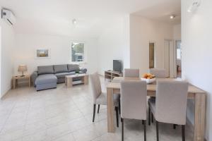 a dining room and living room with a table and chairs at Sea view by Moro 3 in Malinska