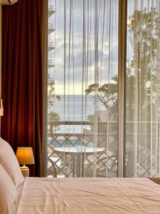 a bedroom with a large window with a view of the ocean at Scorpio Hotel Gonio in Gonio