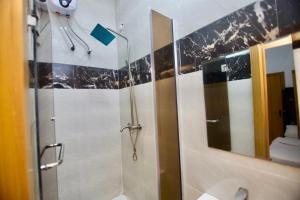 a bathroom with a shower and a mirror at Oasis Villa Lekki in Lekki +36 photos