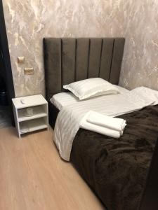 1 dormitorio con 1 cama con 2 toallas en Hotel LION Almaty en Almaty