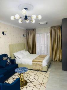 1 dormitorio con 1 cama y 1 sofá azul en Stunning Studio apartment in Kileleshwa en Nairobi