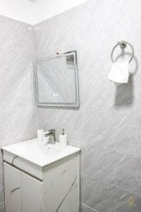 Baño blanco con lavabo y espejo en Stunning Studio apartment in Kileleshwa en Nairobi