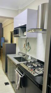 cocina con fregadero y fogones horno superior en Stunning Studio apartment in Kileleshwa en Nairobi