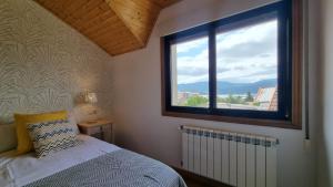 a bedroom with a bed and a large window at Preciosa Villa de 5 dormitorios Rias Bajas in Arcade