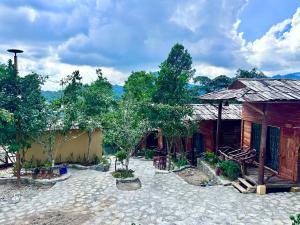 a building with trees in front of it at Bac Ha Charm Stay in Bắc Hà