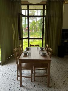 a dining room table with chairs and a large window at Buxus Villas Shekvetili in Shekvetili