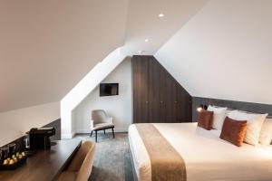 a bedroom with a king sized bed and a staircase at Dukes' Academie Brugge - by Dukes' Hotel Collection in Bruges