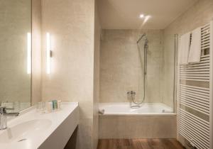 a bathroom with a tub and a sink and a shower at Dukes' Academie Brugge - by Dukes' Hotel Collection in Bruges